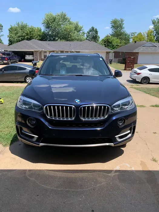 Dark BMW SUV after an exterior detail, parked in a driveway