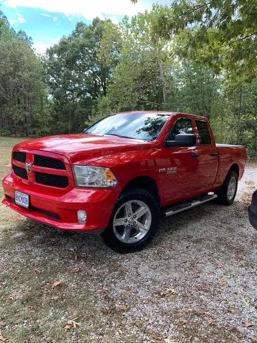 Red Dodge Ram pickup washed and parked on a gravel drive