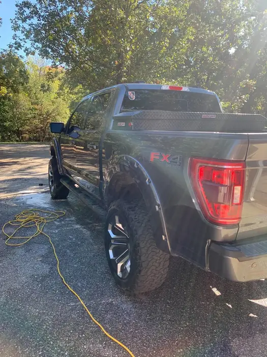 Black pickup truck being rinsed during an exterior hand wash