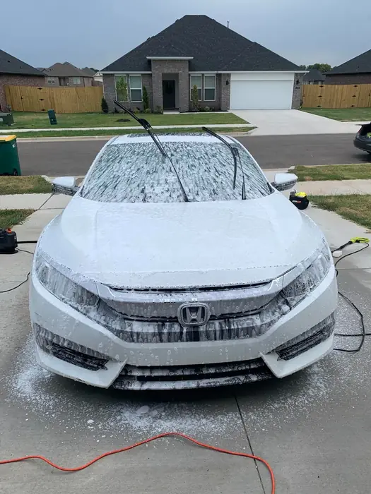 White Honda CR-V covered in snow foam during a hand wash