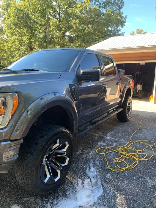 Ford F-150 with cleaning foam on the wheels during an exterior detail