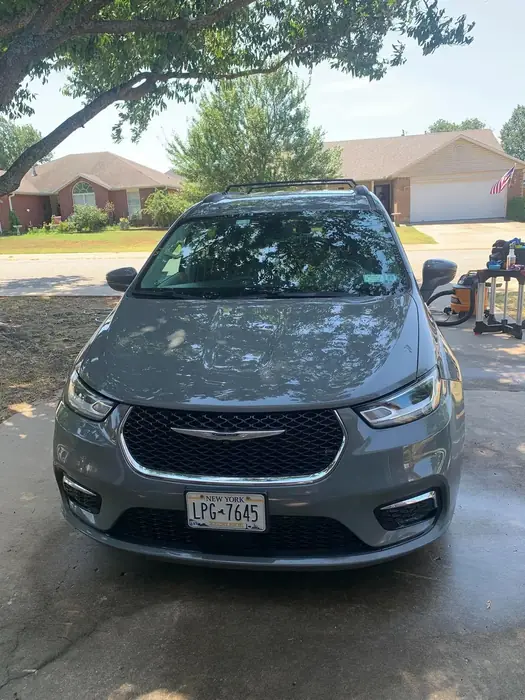 Dark Chrysler minivan cleaned and parked outside a home