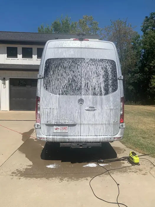 Mercedes-Benz Sprinter van covered in snow foam during a wash