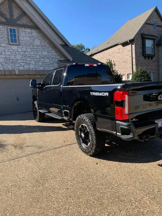 Black pickup truck seen from the rear three-quarter after a full detail